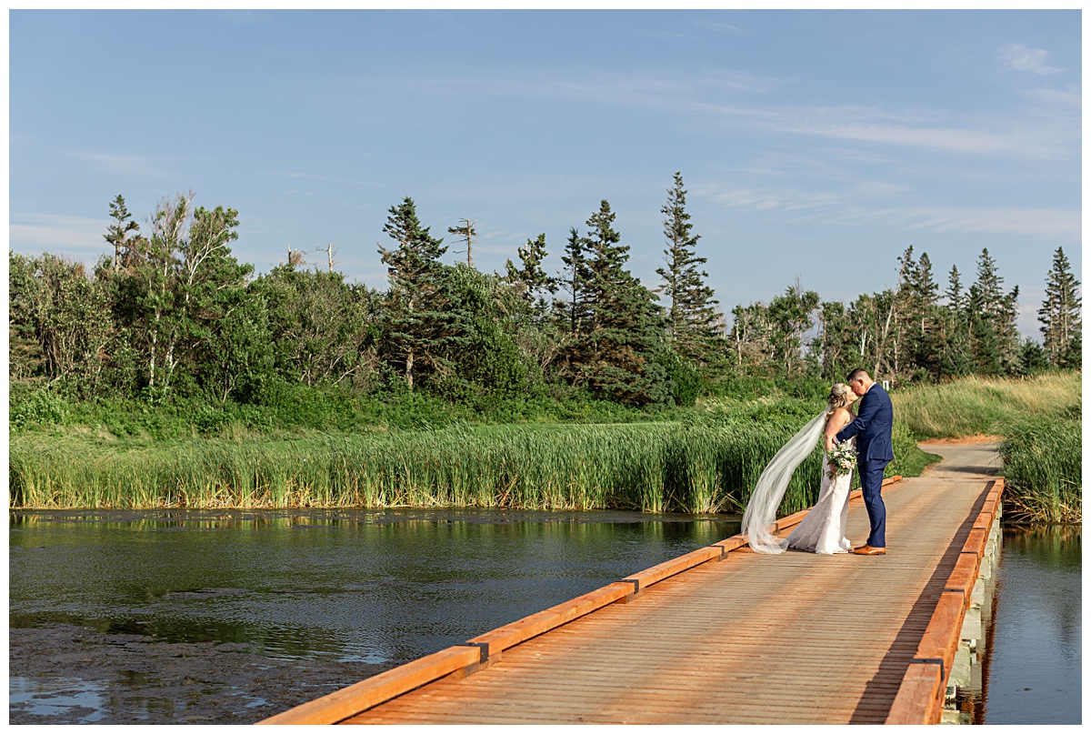 bride and groom posing on bridge at Rodd Crowbush Wedding