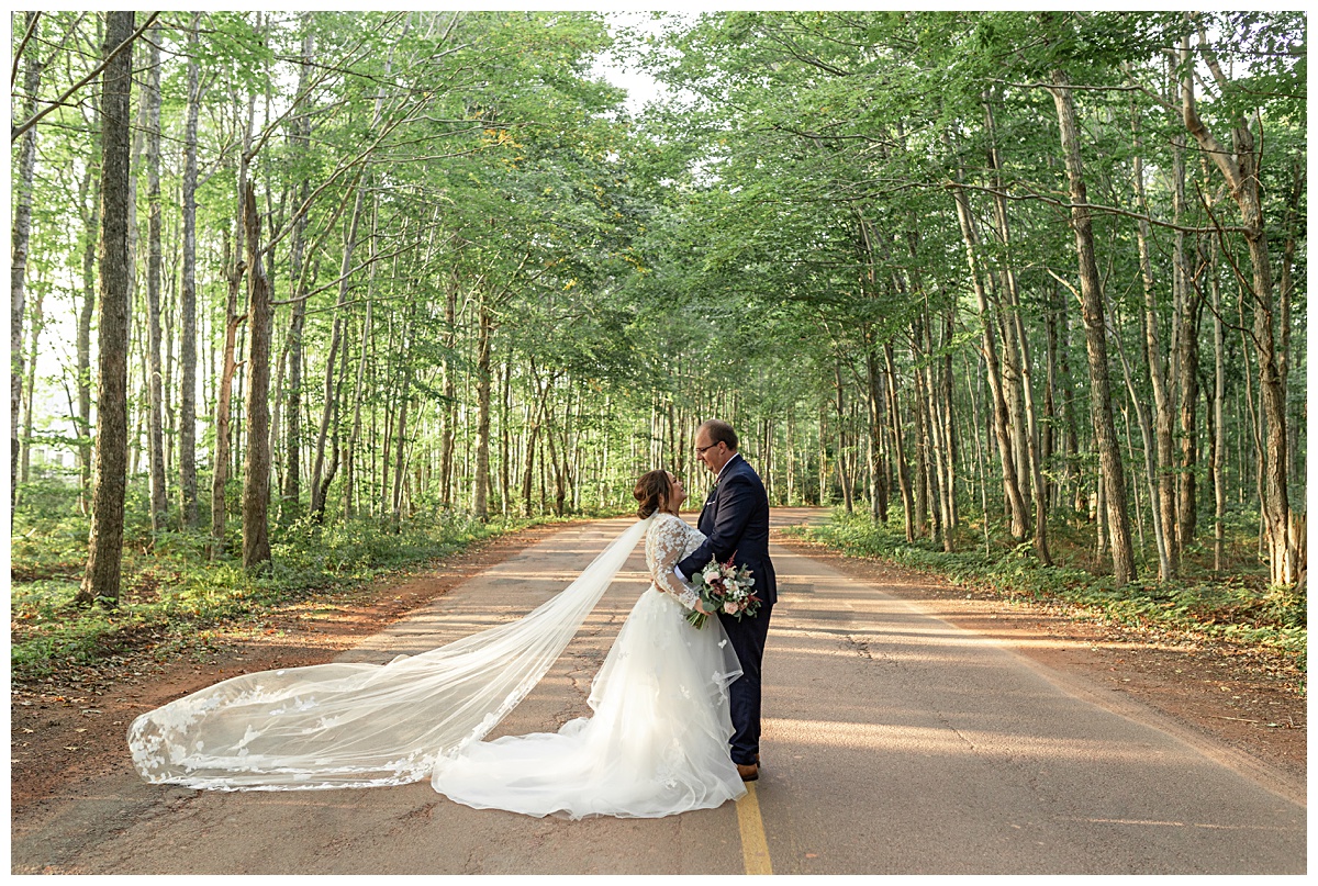 bride and groom embracing on the road at The Mill River Resort