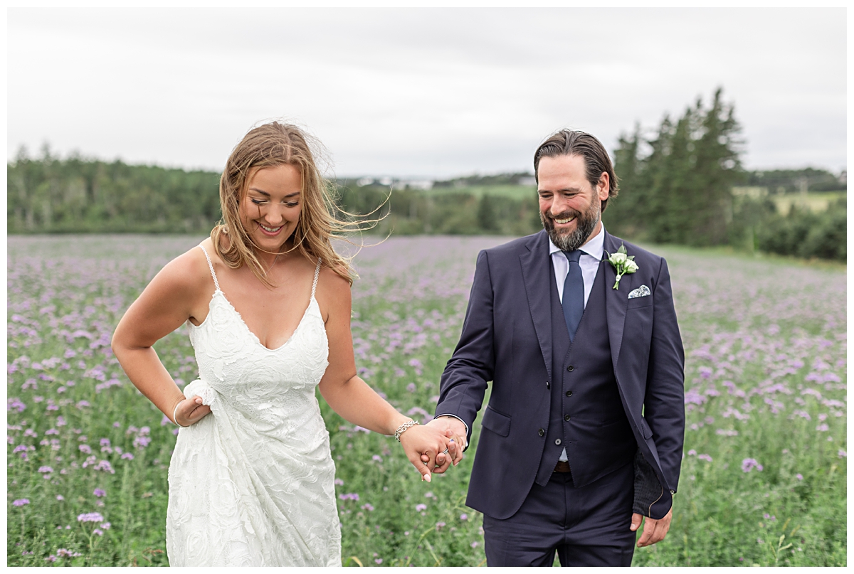 PEI bride and groom walking through flower field
