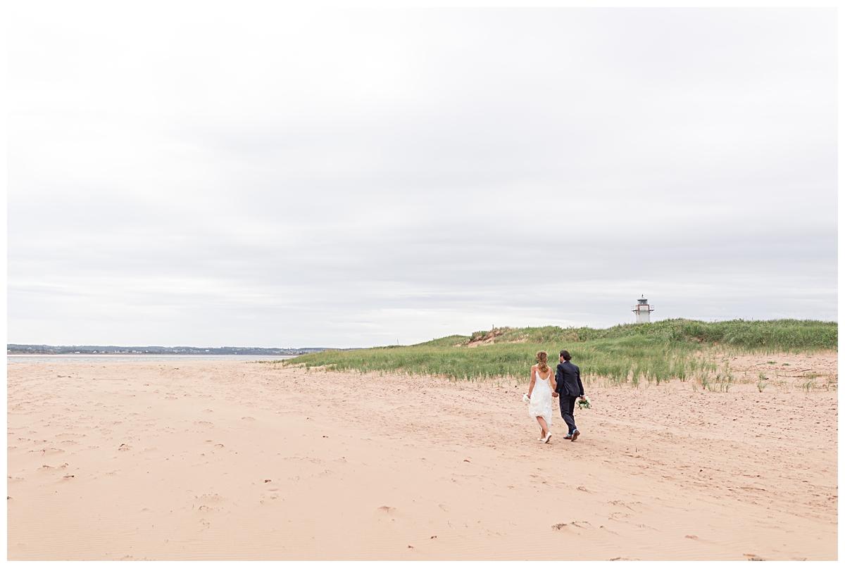 bride and groom walking on New London Beach