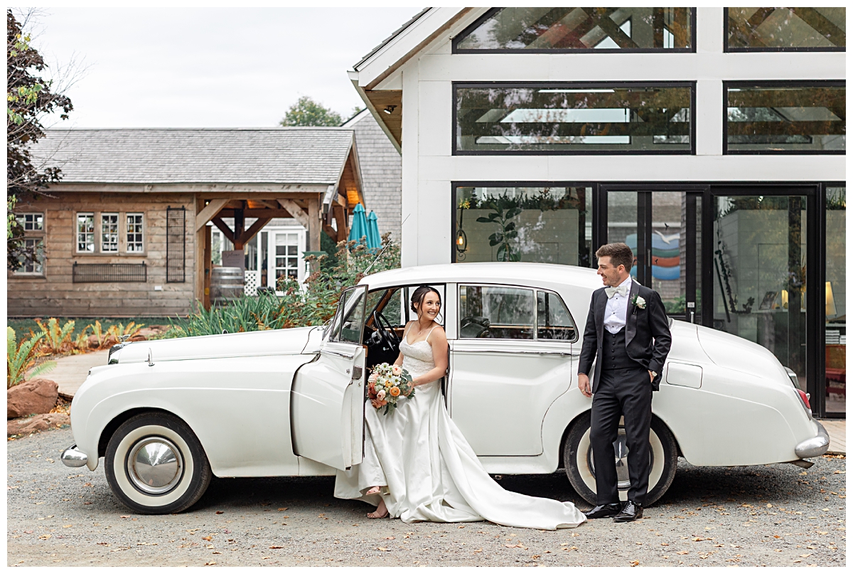 bride and groom standing in front of vintage Bentley car